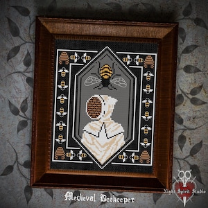 May include: A cross-stitch embroidery design of a medieval beekeeper wearing a white hooded suit and a beehive mask. The beekeeper is surrounded by a border of bees and honeycombs. The design is framed in a dark wood frame. "Medieval Beekeeper" is written below the design.