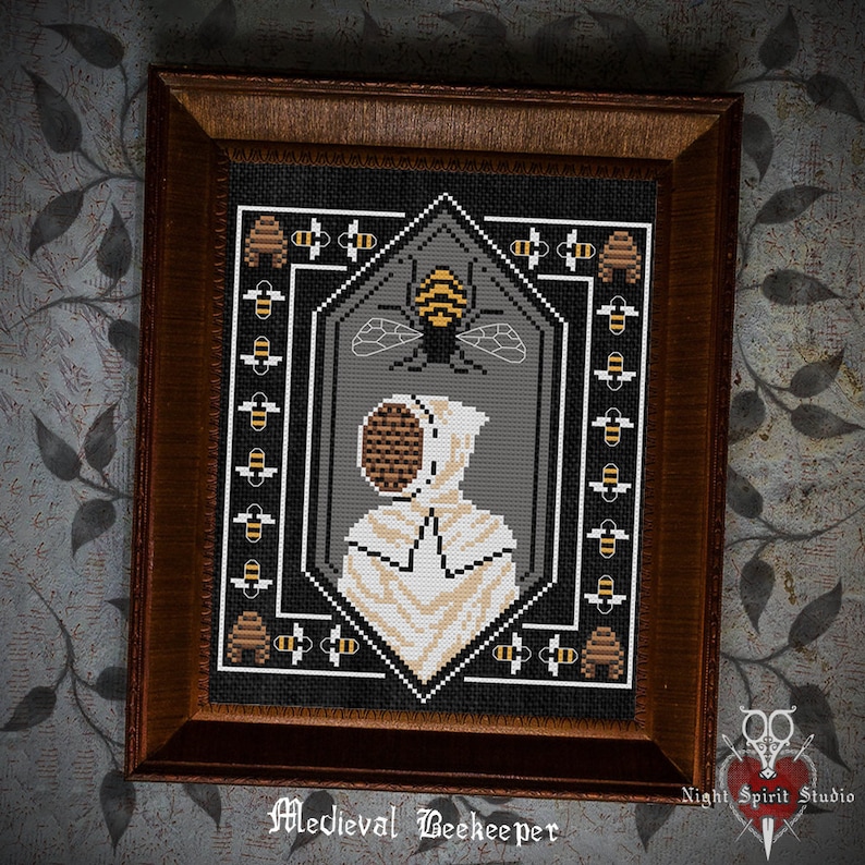 May include: A cross-stitch embroidery design of a medieval beekeeper wearing a white hooded suit and a beehive mask. The beekeeper is surrounded by a border of bees and honeycombs. The design is framed in a dark wood frame. "Medieval Beekeeper" is written below the design.