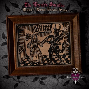 May include: A framed black and white cross-stitch design depicting a woman in a long dress and a horned demon. The title "The Wretch's Sacrifice" and "Witches & Demons Woodcut Series" are above the image. The image is framed in a dark brown wood frame.