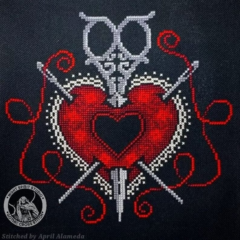 Puede incluir: Patr&oacute;n de punto de cruz de un coraz&oacute;n rojo con un coraz&oacute;n negro en su interior, atravesado por tres agujas y una daga. El coraz&oacute;n est&aacute; rodeado de encaje blanco e hilo rojo. El dise&ntilde;o se titula "Night Spirit Studio Gothic Cross Stitch".
