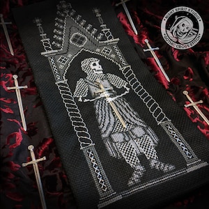 May include: Black and white cross stitch pattern of a skeleton knight standing in a gothic archway. The pattern is framed by a black fabric and includes the text "NIGHT SPIRIT STUDIO GOTHIC CROSS STITCH".