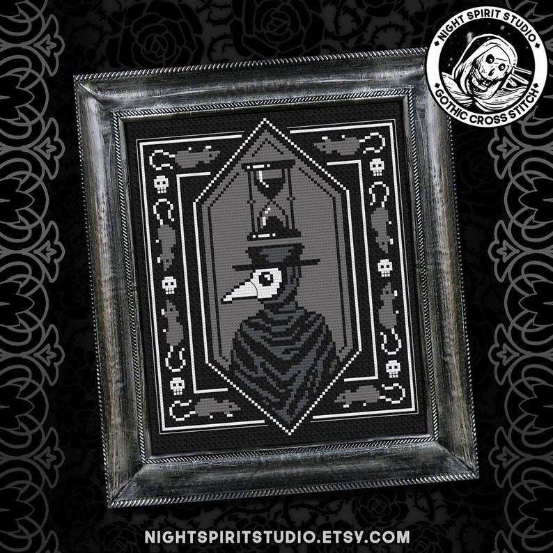 May include: A black and white cross stitch pattern of a plague doctor with a long beak and a hat, holding an hourglass. The pattern is framed in a black frame with a silver border. The frame has the text "Night Spirit Studio Gothic Cross Stitch" on it.