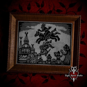 May include: A black and white cross-stitch embroidery framed in a dark wood frame. The embroidery depicts a witch riding a broomstick over a city skyline. The text "Night Spirit Studio" is visible in the bottom right corner.