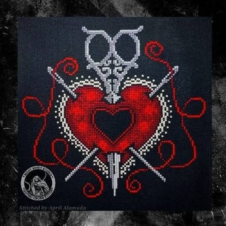 Puede incluir: Patr&oacute;n de punto de cruz con un coraz&oacute;n rojo atravesado por un par de tijeras y agujas. El coraz&oacute;n est&aacute; rodeado de un dise&ntilde;o de encaje blanco y hilo rojo. El dise&ntilde;o est&aacute; bordado en tela negra. El texto "Night Spirit Studio Gothic Cross Stitch" est&aacute; en un c&iacute;rculo en la esquina inferior izquierda. El texto "Stitched by April Alameda" est&aacute; en el centro inferior.