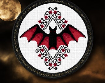 May include: A black and red bat cross stitch pattern with a floral design. The bat is centered in the design and has its wings spread out. The floral design is made up of red flowers and green leaves.