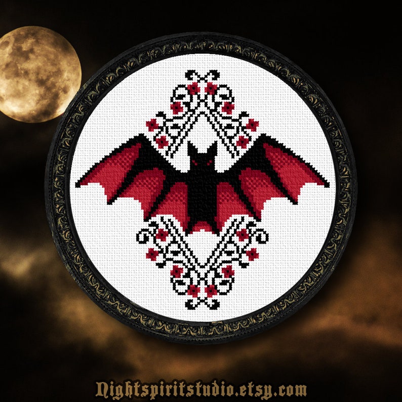 Puede incluir: Un patr&oacute;n de punto de cruz de murci&eacute;lago negro y rojo con un dise&ntilde;o floral. El murci&eacute;lago est&aacute; centrado en el dise&ntilde;o y tiene las alas extendidas. El dise&ntilde;o floral est&aacute; formado por flores rojas y hojas verdes.