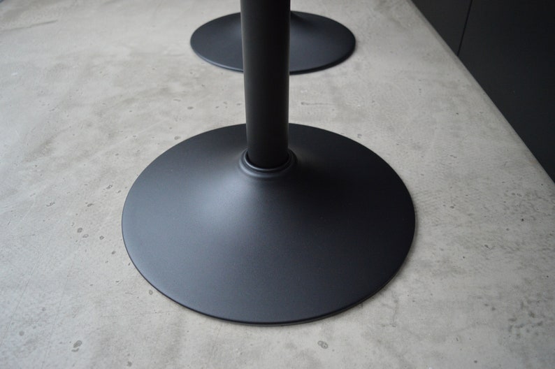 May include: Black metal table base with a wide, round, flat base.
