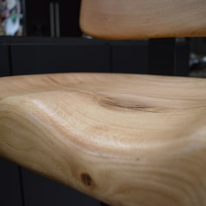 Wooden bar stools tucked under kitchen counter – space-saving design