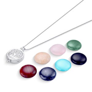 May include: A silver necklace with a tree of life pendant and a set of seven round, colorful stones. The stones are pink, green, blue, beige, dark blue, and red.