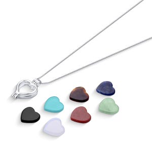 May include: A silver heart-shaped locket necklace with a chain. The locket is open and there are eight heart-shaped stones in different colors: black, white, turquoise, brown, red, green, and blue.