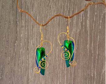May include: A pair of gold earrings with green and blue iridescent beetle wing accents and gold wire detailing.