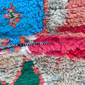 Puede incluir: Primer plano de una alfombra marroqu&iacute; colorida con una variedad de texturas y colores, incluyendo azul, rojo, verde y blanco.