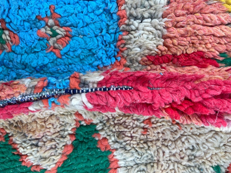 Puede incluir: Primer plano de una alfombra marroqu&iacute; colorida con una variedad de texturas y colores, incluyendo azul, rojo, verde y blanco.