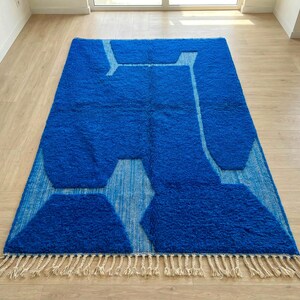 Modern living room with blue Moroccan Berber rug on wooden floor