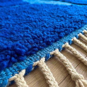 Detail of handmade Moroccan rug edge with soft wool pile and fringe