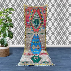 Puede incluir: Una alfombra de corredor marroqu&iacute; colorida con un patr&oacute;n geom&eacute;trico en tonos de rojo, azul, verde y amarillo. La alfombra tiene un borde con flecos y est&aacute; hecha de lana.