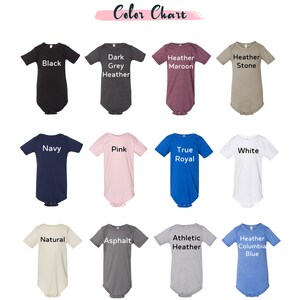 May include: A color chart displaying various baby onesies in different colors. The chart includes colors such as black, dark grey heather, heather maroon, heather stone, navy, pink, true royal, white, natural, asphalt, athletic heather, and heather columbia blue.