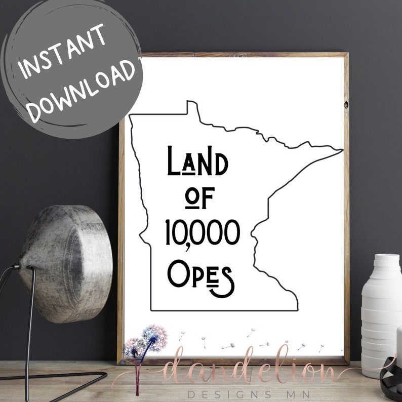 May include: A framed print with a black and white outline of Minnesota. The text "Land of 10,000 Opes" is displayed in a bold, black font. The words "Instant Download" are in a grey circle in the upper left corner.