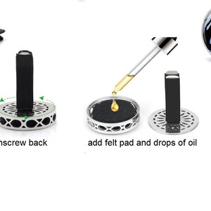 May include: Instructions for using a car air freshener. Unscrew the back of the diffuser, add a felt pad and drops of essential oil, then screw the back on. The diffuser features a silver metal base and a glass top with a design of three cats sitting on a branch under a moon.