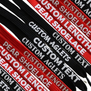 Könnte beinhalten: Nahaufnahme von mehreren schwarzen und roten Schnürsenkeln mit weißem Text. Der Text auf den Schnürsenkeln lautet "Custom Length", "Pear Shoelace", "Custom Aglets", "Custom Text".
