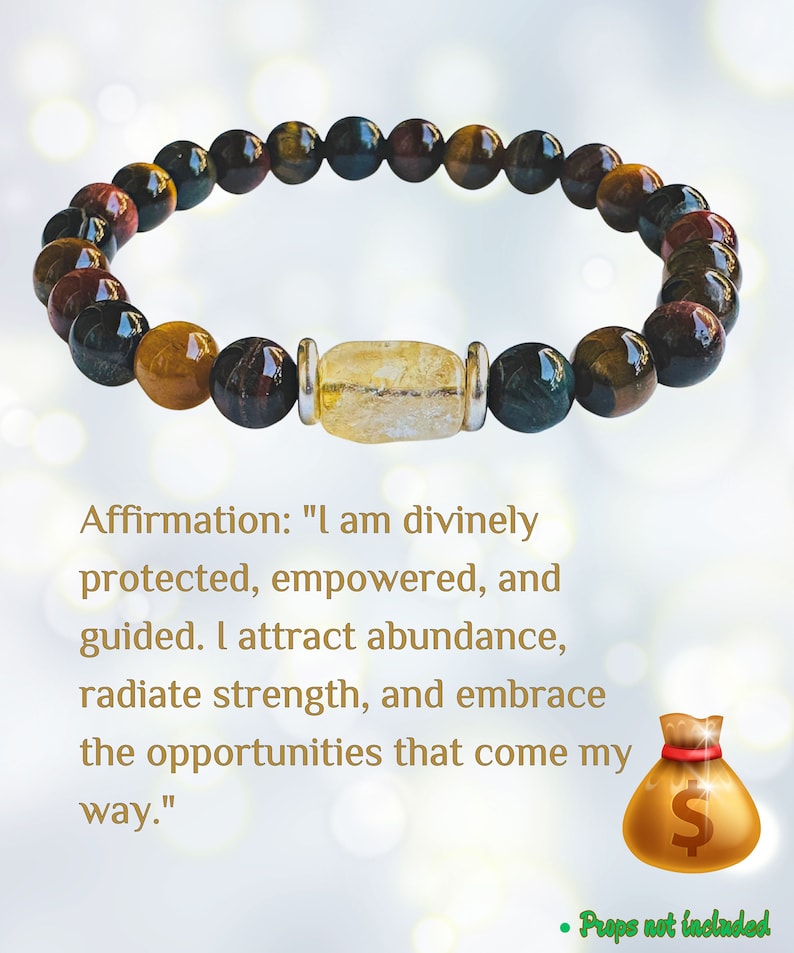 K&ouml;nnte beinhalten: Ein Armband mit Tigerauge-, Rotjaspis- und Goldstone-Perlen. Das Armband hat einen Anh&auml;nger aus klarem Quarzkristall und einen silbernen Akzent. Die Affirmation "Ich bin g&ouml;ttlich besch&uuml;tzt, erm&auml;chtigt und gef&uuml;hrt. Ich ziehe F&uuml;lle an, strahle St&auml;rke aus und umarme die M&ouml;glichkeiten, die mir begegnen." steht unter dem Armband.