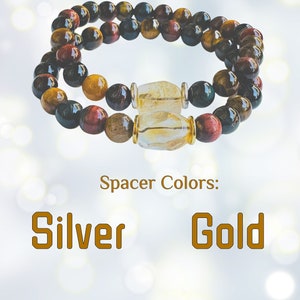 K&ouml;nnte beinhalten: Zwei &uuml;bereinanderliegende Armb&auml;nder mit Tigerauge, rotem Jaspis und schwarzen Onyx-Perlen. Die Armb&auml;nder haben klare Quarz-Abstandshalter mit silbernen oder goldenen Akzenten. Farben der Abstandshalter: Silber Gold