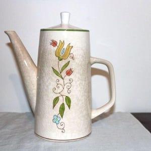 May include: A set of three ceramic mugs with a speckled, matte finish. The mugs are in shades of cream, light gray, and dark gray. Each mug has a simple, minimalist design, perfect for coffee or tea.