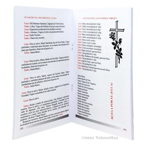 K&ouml;nnte beinhalten: Offenes Buch mit spanischem Text und einem schwarzen Kreuz mit Rosenillustration. Der Text enth&auml;lt Gebete und religi&ouml;se Phrasen. Das Buch ist auf den Seiten 32 und 33 ge&ouml;ffnet.