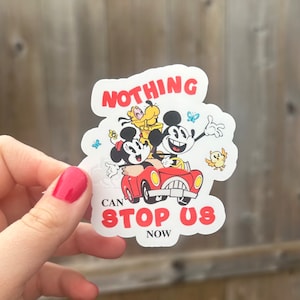 May include: A white sticker with a red car, Mickey Mouse, Minnie Mouse, and Pluto. The sticker says "Nothing Can Stop Us Now".