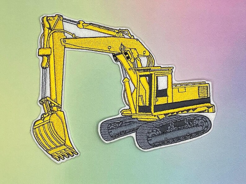 K&ouml;nnte beinhalten: Gestickter Aufn&auml;her mit einem gelben Bagger mit schwarzen und grauen Details. Das Bauger&auml;t ist im Profil dargestellt, mit einem detaillierten Eimer und Ketten. Der Aufn&auml;her hat einen wei&szlig;en Rand und ist vor einem pastellfarbenen Hintergrund platziert.