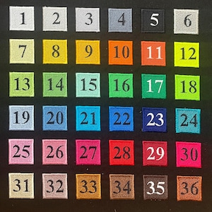 K&ouml;nnte beinhalten: Eine Sammlung von 36 quadratischen, gestickten Aufn&auml;hern, jeweils mit einer Nummer von 1 bis 36. Die Aufn&auml;her haben verschiedene Farben, darunter Grau, Gelb, Orange, Gr&uuml;n, Blau, Rosa, Rot und Braun, mit wei&szlig;en Zahlen.