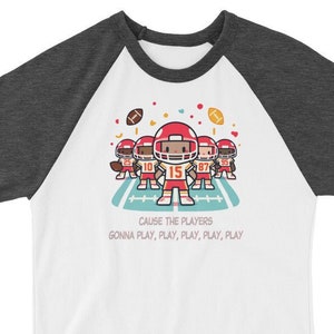 May include: A white and grey baseball t-shirt with a red and white cartoon football player design. The text on the shirt reads "Cause the players gonna play, play, play, play, play."