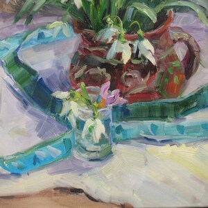 May include: An oil painting depicts a still life with a brown pitcher filled with white snowdrop flowers and green leaves. A small glass vase holds more snowdrops and a few pink flowers. A blue and green ribbon drapes across a white tablecloth.