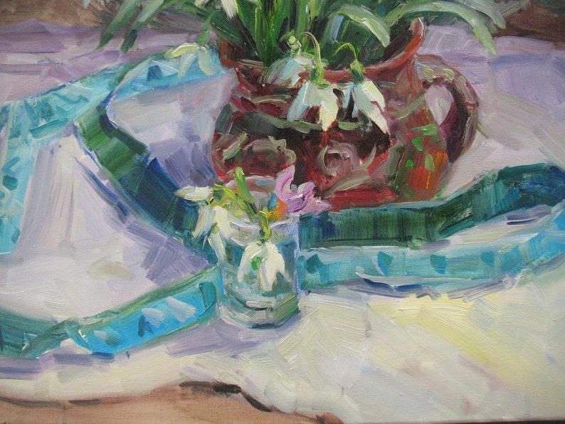 May include: An oil painting depicts a still life with a brown pitcher filled with white snowdrop flowers and green leaves. A small glass vase holds more snowdrops and a few pink flowers. A blue and green ribbon drapes across a white tablecloth.