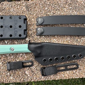 May include: A tactical knife set with a mint green handle and black sheath. Includes a Tek-Lok mounting system, two black straps, and two belt clips. The knife is made in the USA.