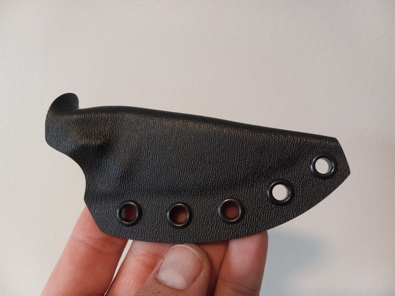 K&ouml;nnte beinhalten: Schwarze Ledertasche f&uuml;r ein Messer mit f&uuml;nf schwarzen Metall&ouml;sen.