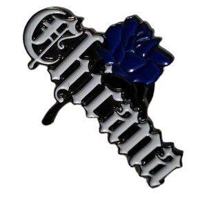 May include: A black and white enamel pin with the word "Forever" in a gothic font. A blue rose is on the left side of the pin.