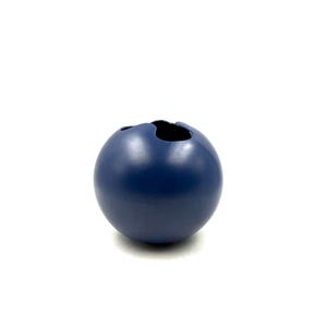 Könnte beinhalten: Eine marineblaue, kugelförmige Keramikvase mit einer organischen Öffnung an der Oberseite. Die Vase hat eine glatte, matte Oberfläche und steht vor einem weißen Hintergrund. Diese dekorative Vase eignet sich zum Präsentieren von Blumen oder als eigenständiges Kunstwerk.