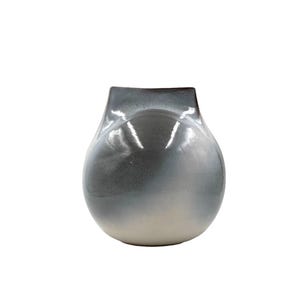May include: A ceramic vase with a white and grey ombre glaze. The vase has a rounded, bulbous shape with a wide opening at the top.