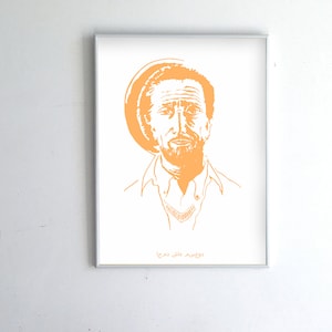 May include: A framed print of a man with a beard and a hat. The image is in orange and white. The text "Moussa Mallé" is at the bottom of the print.
