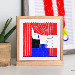 Puede incluir: Una ilustración enmarcada de una persona mirando a través de cortinas rojas con una lágrima azul en la mejilla. El texto "Je ne sais pas" es visible en el fondo.