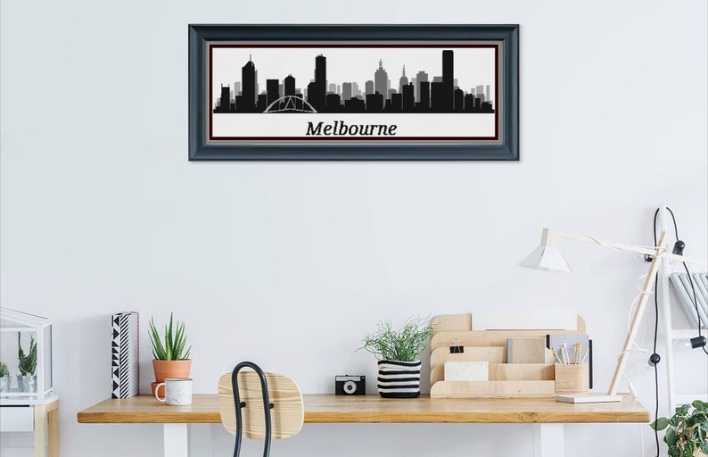 May include: Framed black and white Melbourne skyline art print. The cityscape silhouette includes iconic buildings and a bridge, set against a white background. The word "Melbourne" is printed below the skyline.