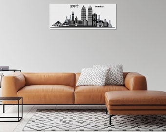 May include: A black and white cityscape print of Mumbai, India, hangs above a brown leather sofa. The print features the city's skyline with the text "Mumbai" and text in a different language. The room also includes a black side table, a patterned rug, and a matching ottoman.