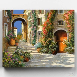 May include: A painting of a narrow, cobblestone street in a European village. The street is lined with buildings with arched doorways and windows. The buildings are covered in vines and flowers. There are terracotta pots with flowers and plants on the street.