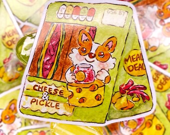 Könnte beinhalten: Ein farbenfroher Aufkleber mit einem Cartoon-Corgi, der ein Glas Marmelade hält, mit einem Käseblock und dem Text "Cheese & Pickle". Der Hintergrund zeigt eine Sandwich-Illustration und den Text "Meal Deal".