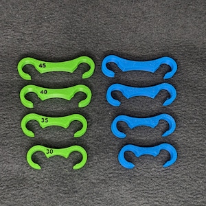 May include: Four green and four blue plastic ring sizers, each with a number printed on it. The numbers are 30, 35, 40, and 45.