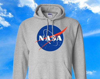 May include: A gray hooded sweatshirt with the NASA logo printed on the front. The logo is blue with a red swoosh and white stars.