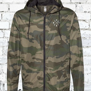 May include: A camouflage green hooded jacket with a black zipper and a white logo on the front that says "NPI" with a pine tree and arrows.