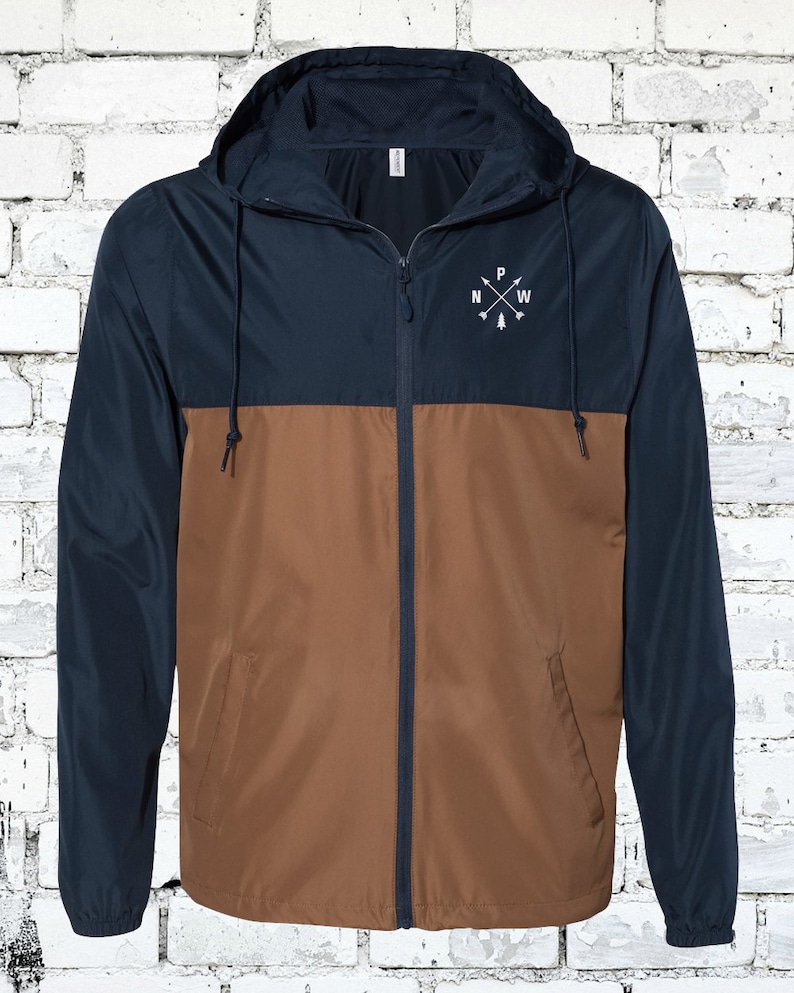 May include: A navy blue and brown hooded jacket with a zipper closure. The jacket has a compass design with the letters "N", "W", "P", and "E" on the front.