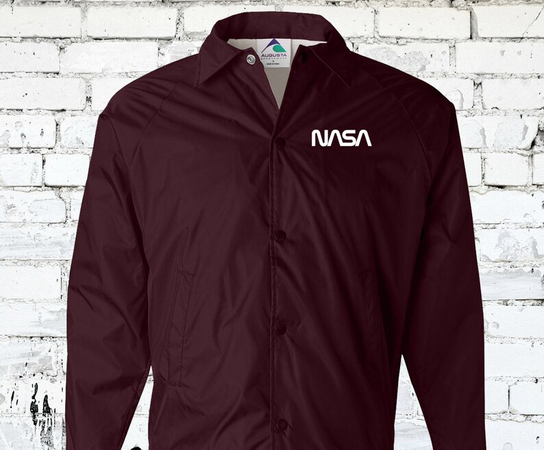 Puede incluir: Una chaqueta de b&eacute;isbol granate con un logotipo de la NASA blanco en el pecho izquierdo.